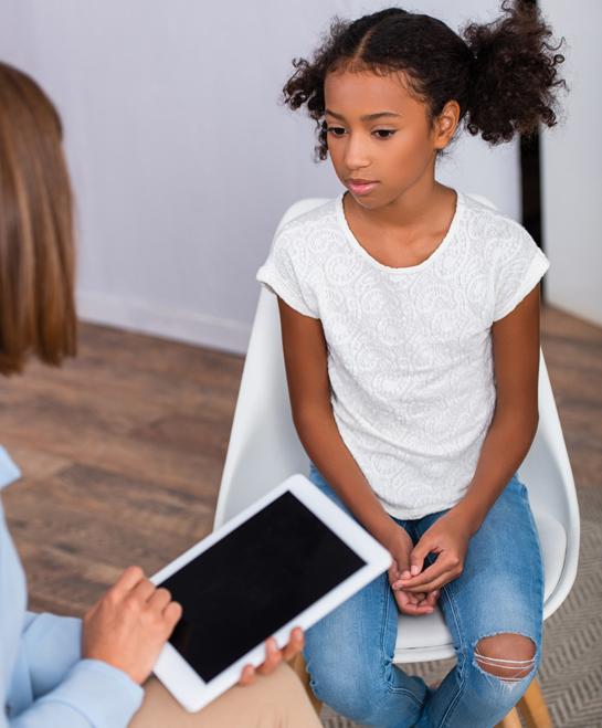 Clinician using tablet to interview a 10 year old